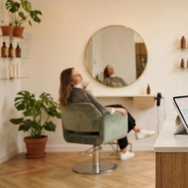 Jasny salon z klientką w fotelu przed lustrem